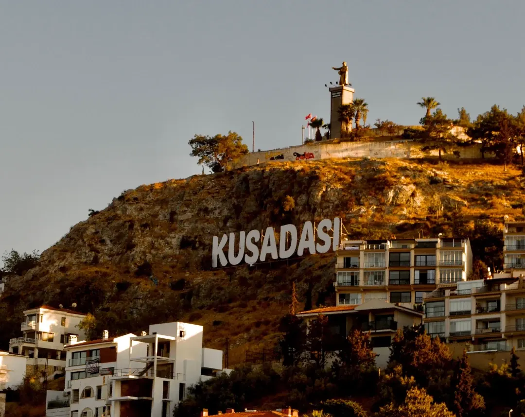 Kuşadası yazısı ve heykelin bulunduğu tepe — İzmir Adnan Menderes Havalimanı (ADB) Kuşadası transfer rotası